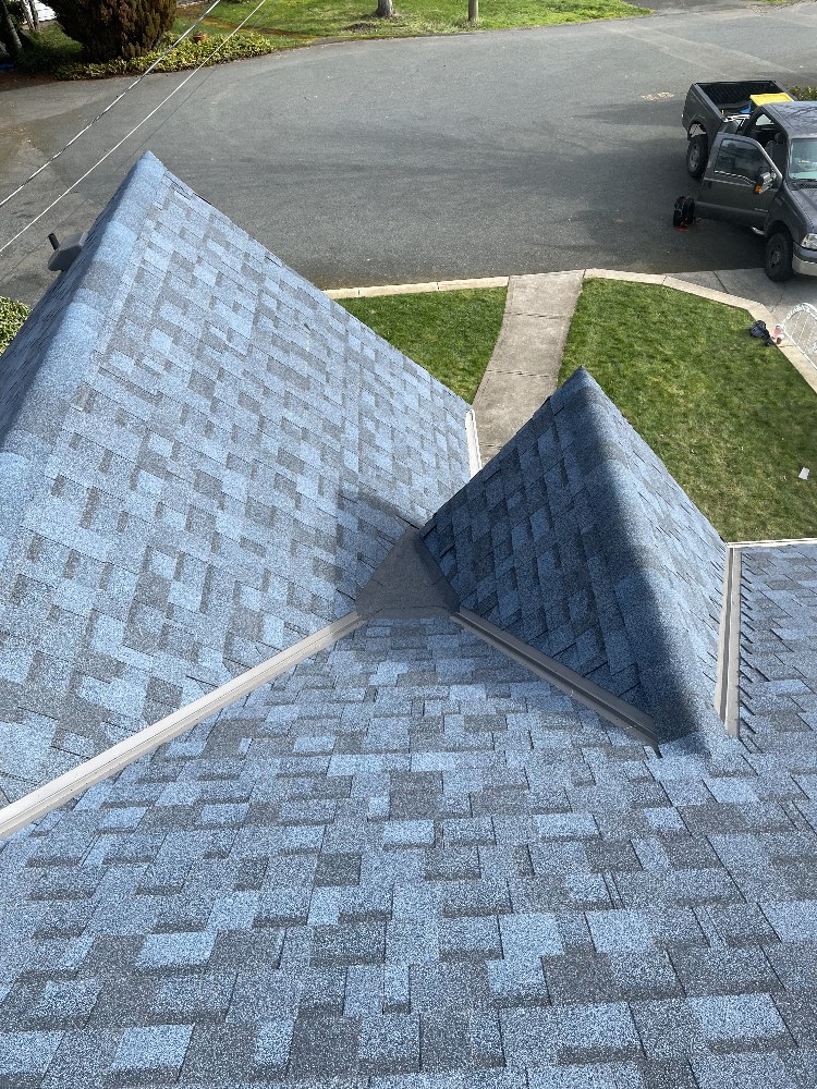 Hip and valley shingle work viewed from the ridge of a home